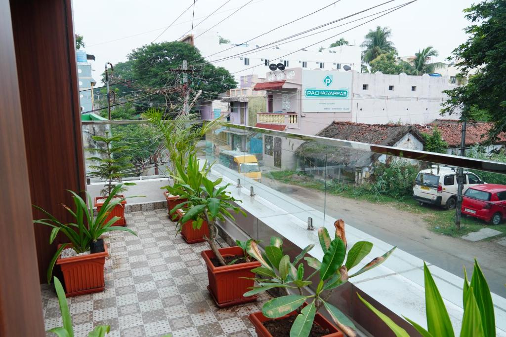 uma varanda com plantas e vista para uma rua em L. R RESIDENCY em Kanchipuram