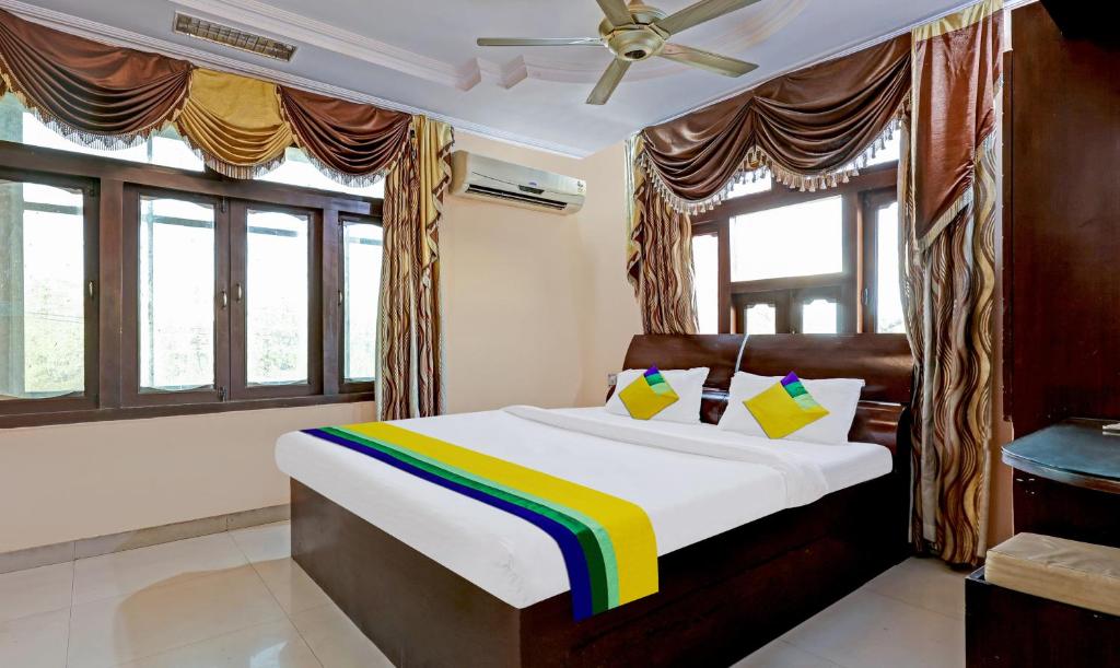 1 dormitorio con cama de arco iris en una habitación con ventanas en Itsy By Treebo - Friends, en Haldwāni