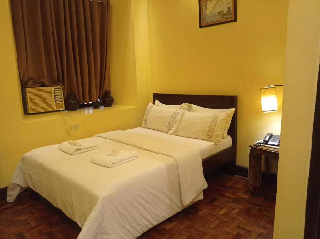 a bedroom with a bed with two towels on it at RF ANICETO MANSION in Vigan