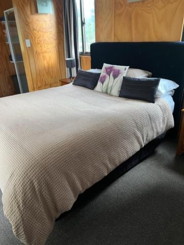 um quarto com uma cama grande e almofadas em Westmere Retreat em Westmere