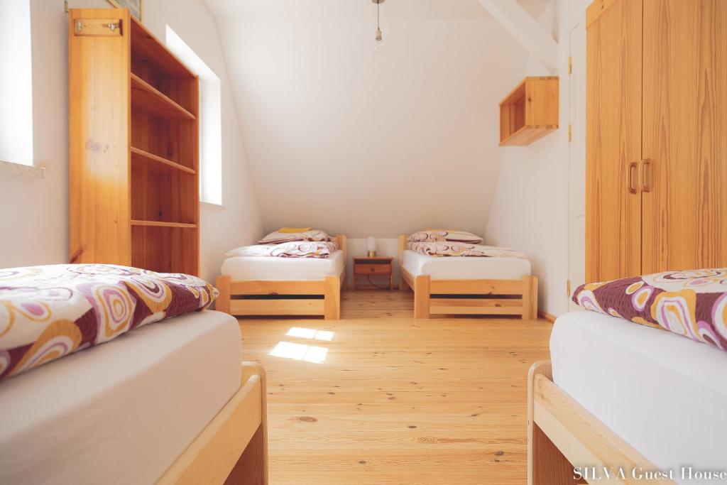 Habitación con 2 camas en una habitación en SILVA Guest House - dom wczasowy, tenis, basen, balia i sauna, en Borsk