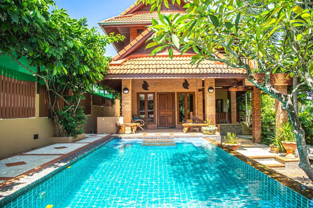 a swimming pool in front of a villa at Kata Pool Villa ​No.7 in Kata Beach