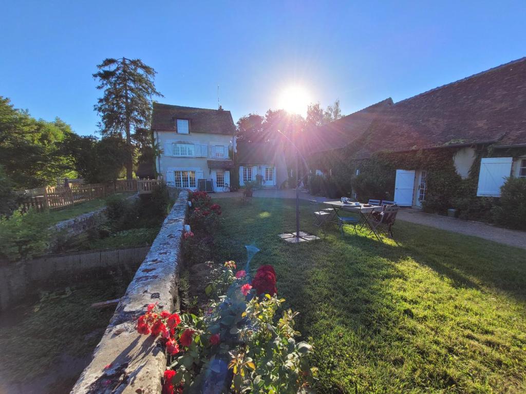 a house with a garden with flowers in the yard at Le Moulin du Châtelier in Paulmy