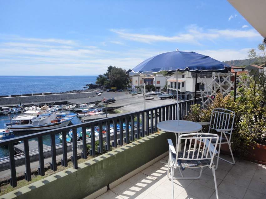 a balcony with a table and chairs and the water at Acirealevacanze - Romantica Camera sul Mare in Acireale