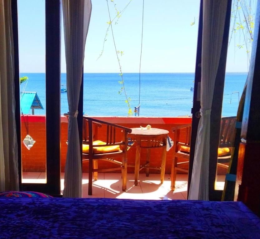 a room with a view of the ocean from a balcony at Pelangi Beach Homestay in Amed