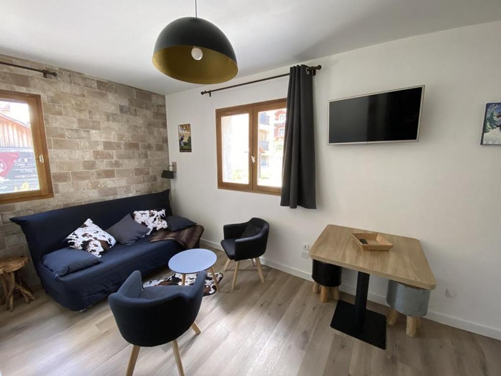 sala de estar con sofá azul y mesa en Appartement Montgenèvre, 2 pièces, 4 personnes - FR-1-266-107 en Montgenèvre