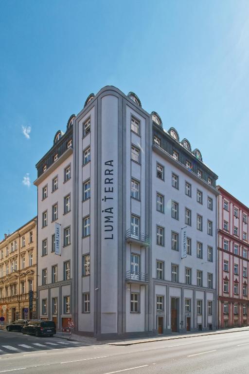 Un gran edificio con un cartel al costado. en Luma Terra Prague Hostel, en Praga