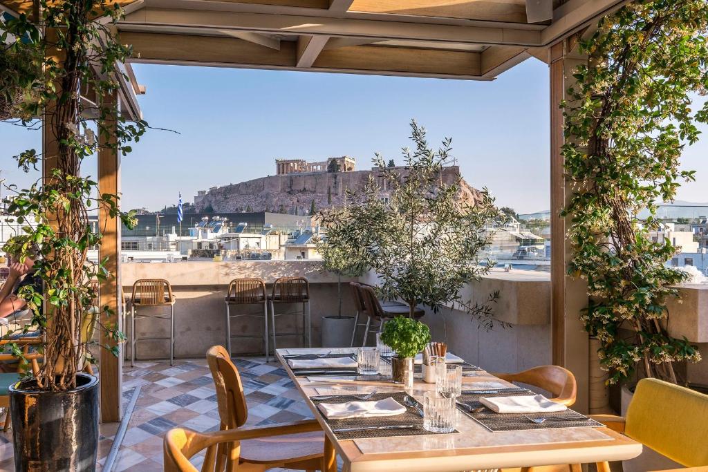 a table on a balcony with a view of the city at Niche Hotel Athens in Athens