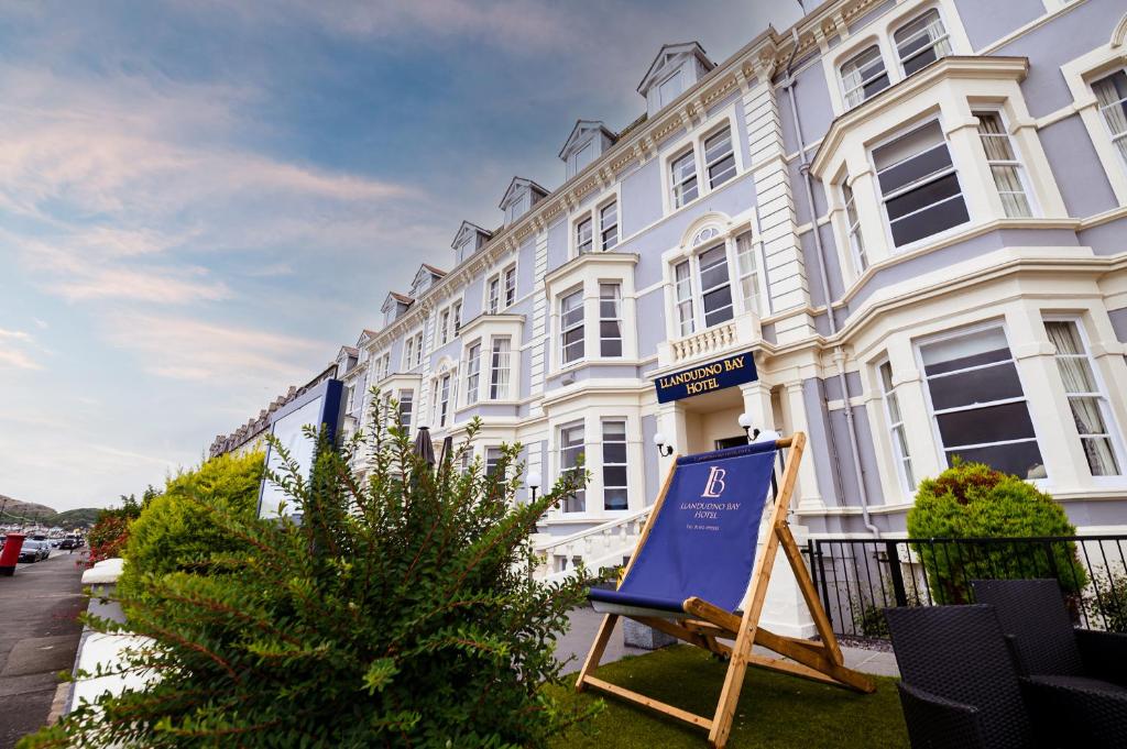 a sign in front of a white building at Llandudno Bay Hotel in Llandudno