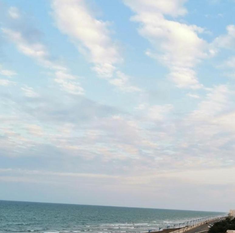 un pont sur l'océan avec un ciel nuageux dans l'établissement Marina H, à Sohar