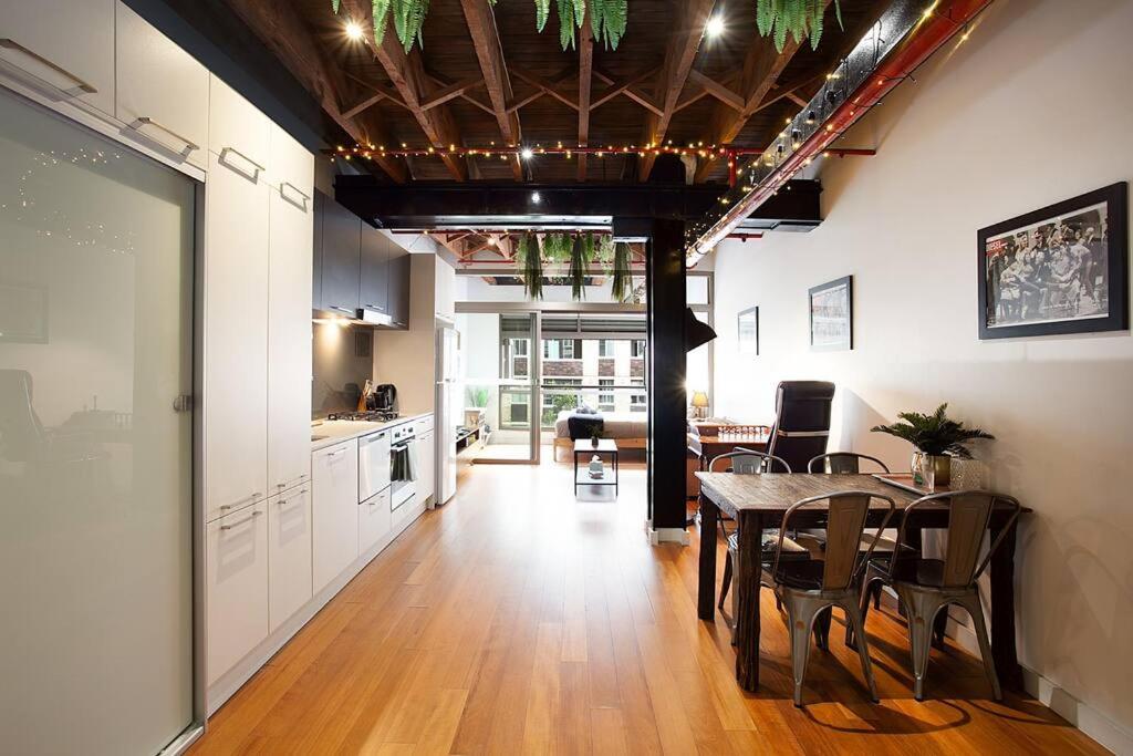 cocina y comedor con mesa y sillas en New York Style Warehouse Loft by Sydney Dreams, en Sídney