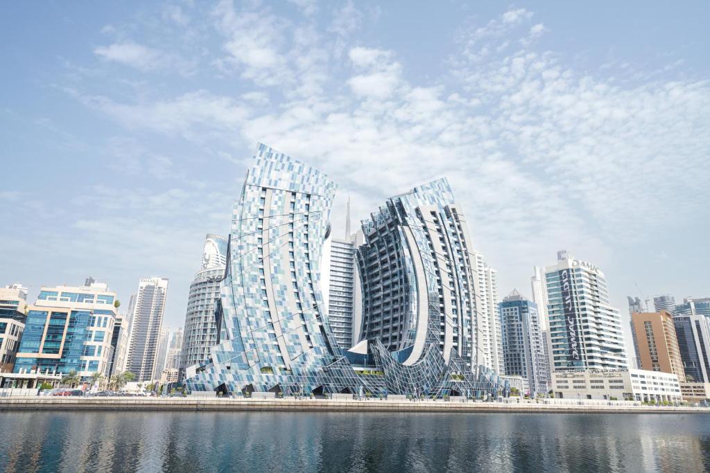 Lusso Hometels J One Business Bay في دبي: مجموعة مباني طويلة في مدينة بجوار الماء
