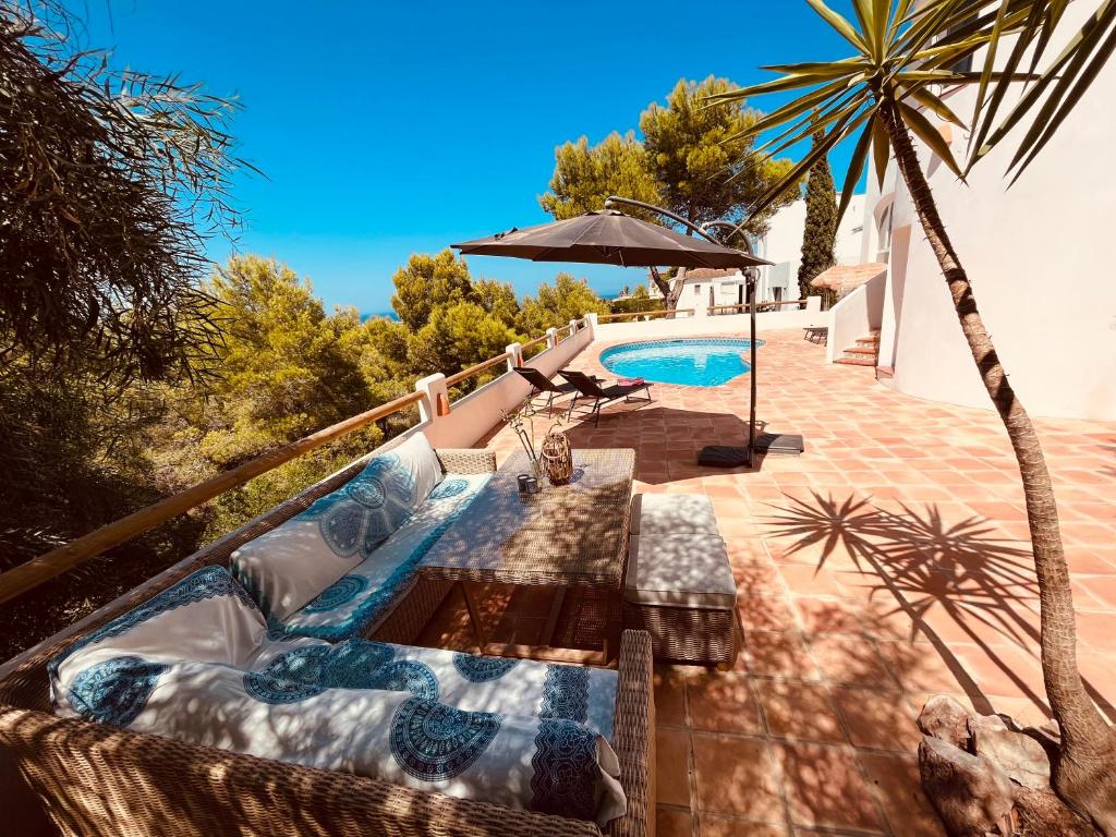 a swimming pool with a table and an umbrella at Ibiza Dream Villa Denia, Seaview, Pool, BBQ, Airco, Wifi in Denia