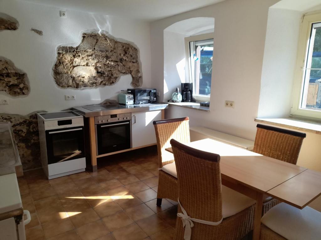 a kitchen with a table and a table and chairs at Haus Guttenberg in Guttenberg