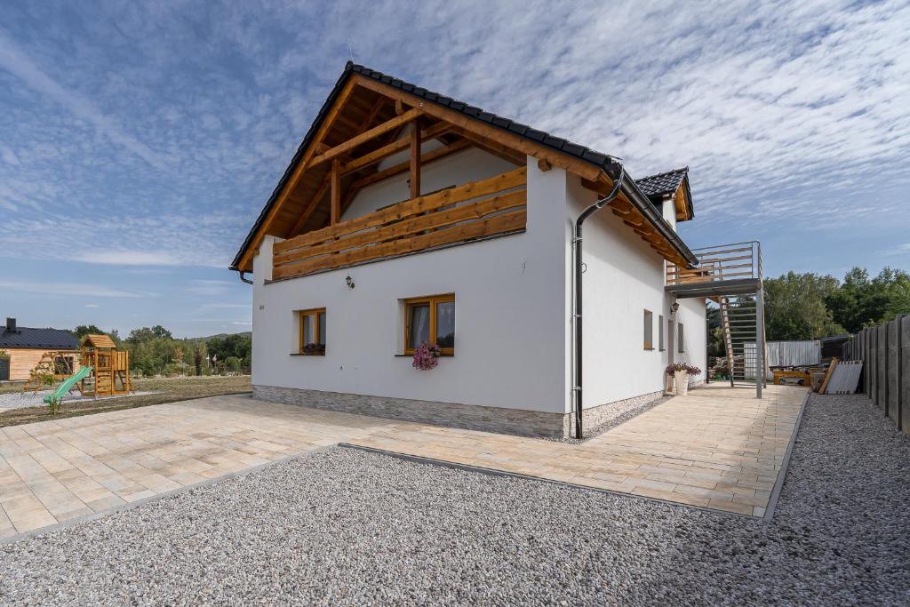 uma pequena casa branca com um telhado de madeira em EVerLuck em Loket
