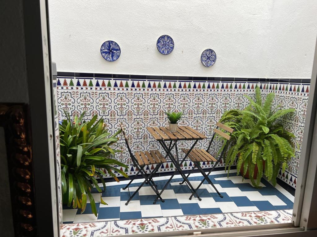 balcón con mesa y placas azules en la pared en Las Parras House - Casa en Torredelcampo, en Torredelcampo