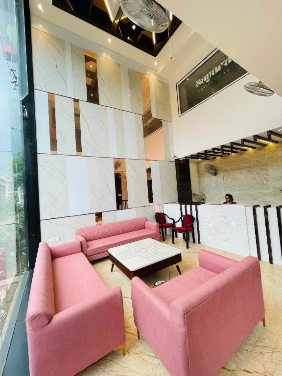 コーターにあるHOTEL NAYARAのピンクのソファとコーヒーテーブルのあるロビー