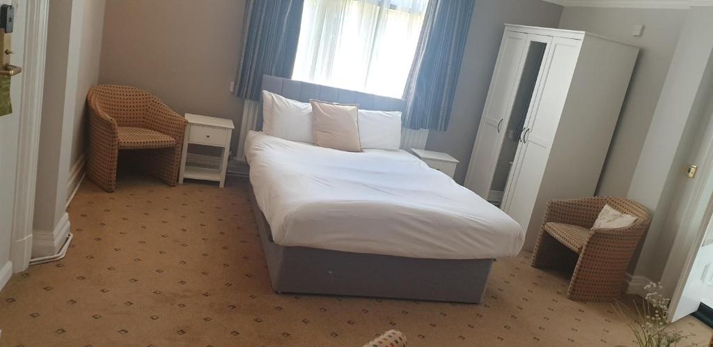 a bedroom with a large bed and a window at The Tudor Hotel in Harrow