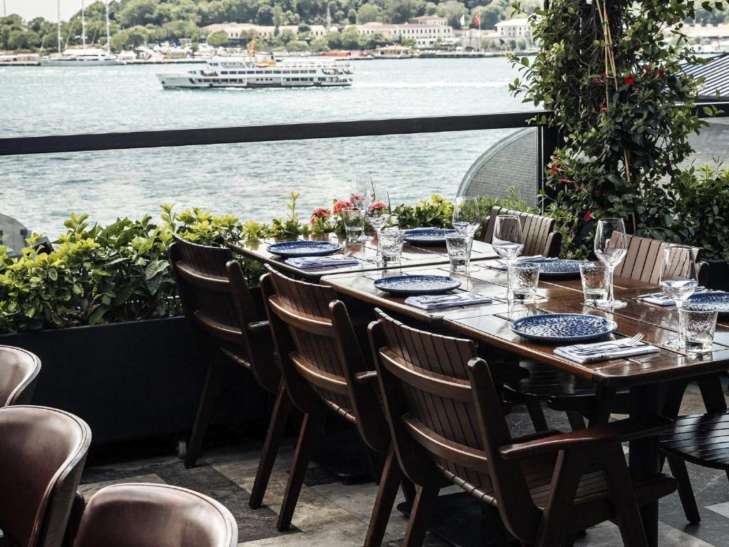 a table with chairs and a view of the water at Novotel Istanbul Bosphorus Hotel in Istanbul
