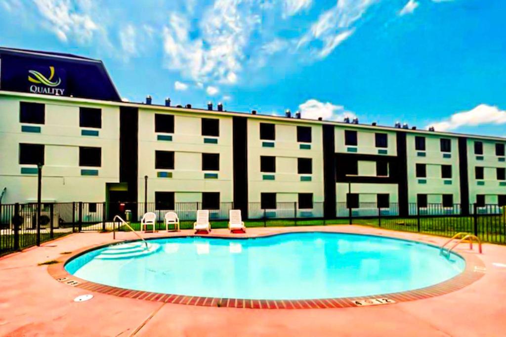 a hotel with a swimming pool in front of a building at Quality Inn & Suites Lake Charles in Lake Charles