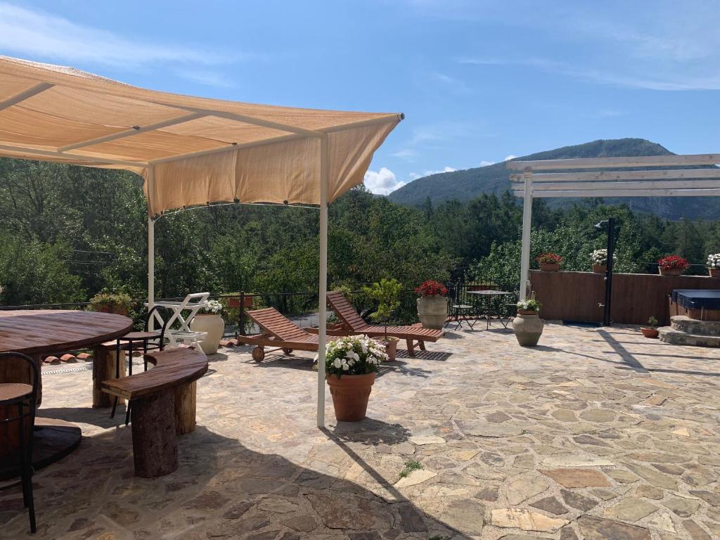 d'une terrasse avec des tables, des chaises et un grand parasol. dans l'établissement Ai Cerri di Remí, à Lauria Inferiore