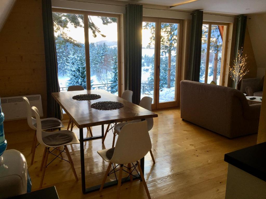 a dining room with a table and chairs and a couch at Pine Cabins Zlatibor in Zlatibor