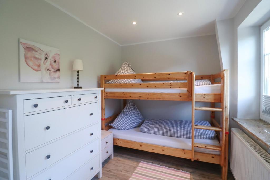 ein Kinderschlafzimmer mit einem Etagenbett und einer Kommode in der Unterkunft Bauernhof FeWo II Gänseblümchen in Schwienkuhl an der Ostsee in Schwienkuhl