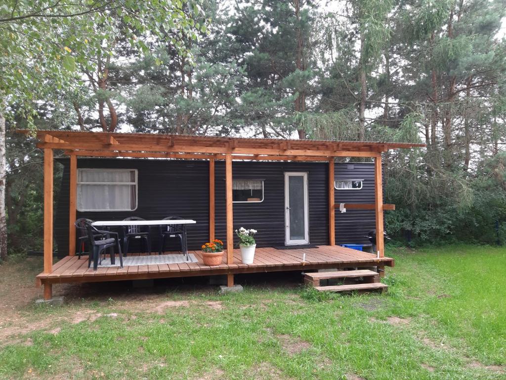 a tiny house with a porch and a table at Domek holenderski w Stadnine Koni Mazury in Łukta