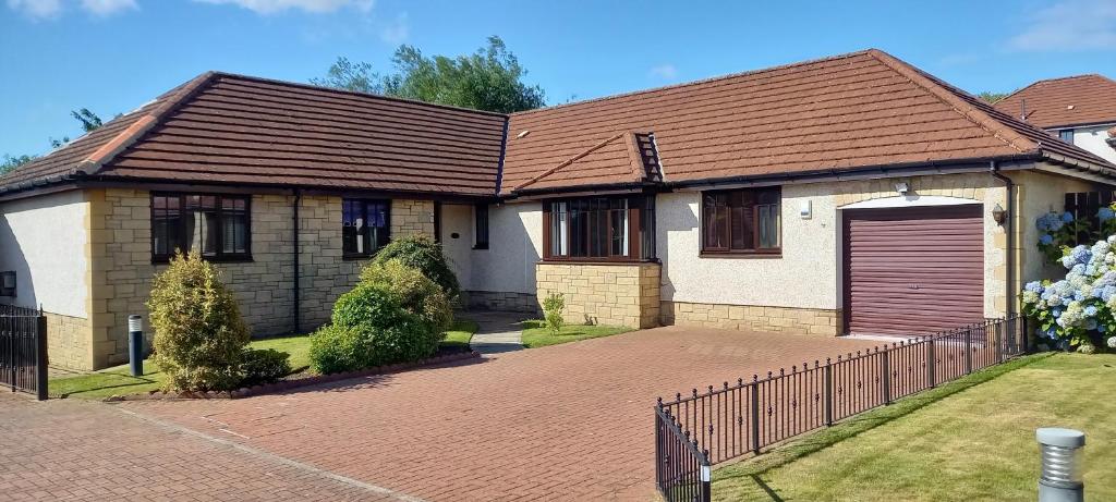 een huis met een bruin dak en een oprit bij Holiday Home Schwabenhaus in Kirkcaldy