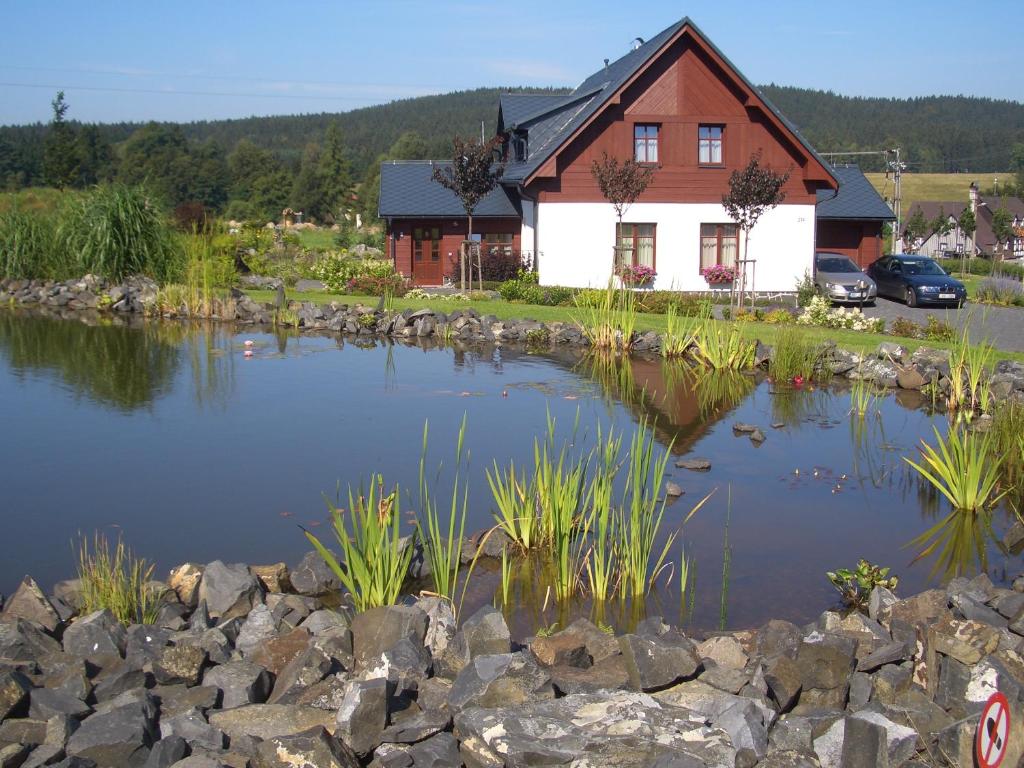 ein großer Teich vor einem Haus in der Unterkunft Doubické chalupy in Doubice