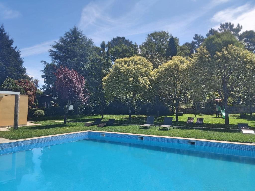 a large swimming pool in a yard with trees at Quinta Vale do Homem in Amares