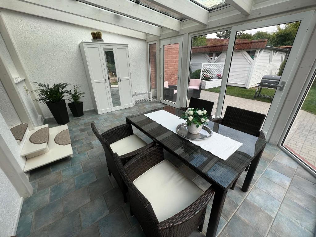 a patio with a table and chairs on a patio at Familienfreundliche Ferienwohnung mit Wintergarten in Badow