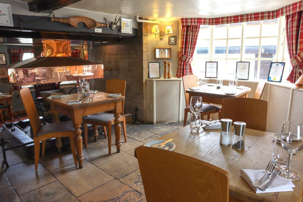 un restaurante con mesa y sillas y un comedor en The Kings Arms Inn en Oakham