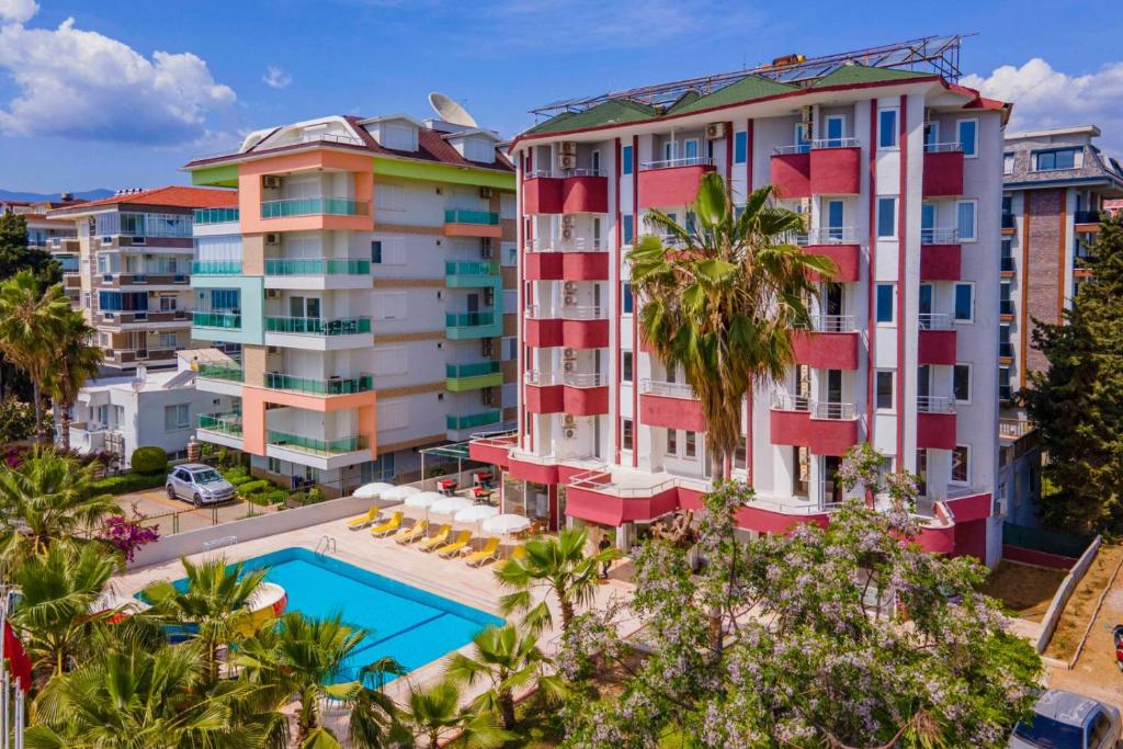 阿拉尼亞的住宿－MİKADO BEACH HOTEL，享有带游泳池和棕榈树的建筑的空中景致