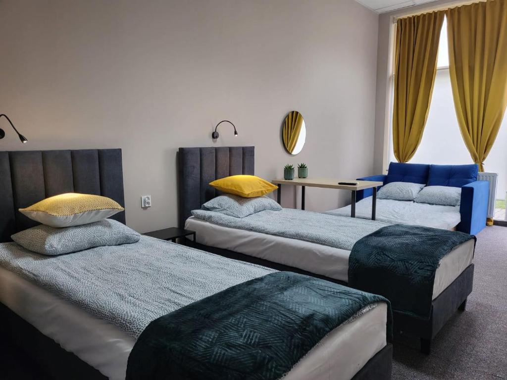 een slaapkamer met 2 bedden en een tafel en een stoel bij Apartamenty CITI in Siechnice