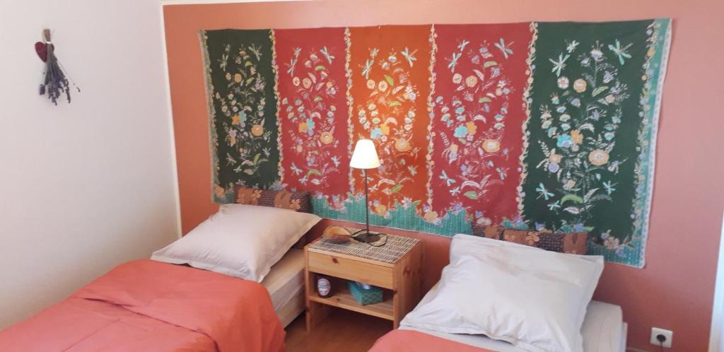 a bedroom with two beds and a painting on the wall at Chambre Aqualine in Aywaille