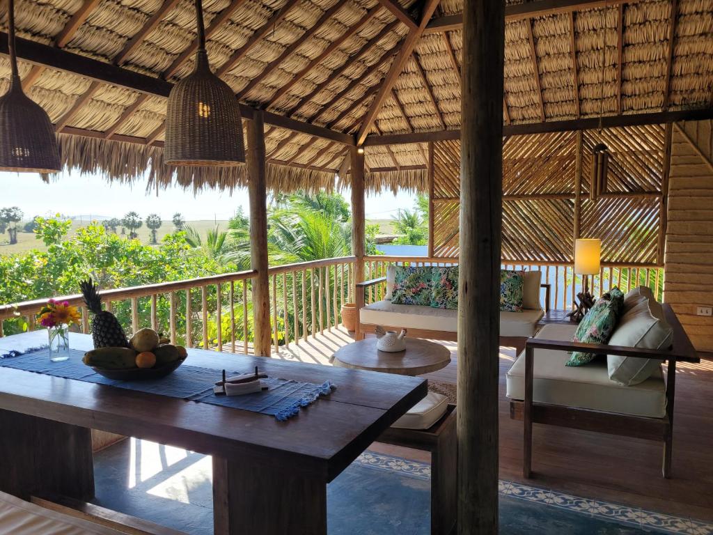 a living room of a resort with a wooden table at Bangalo Das Dunas in Prea