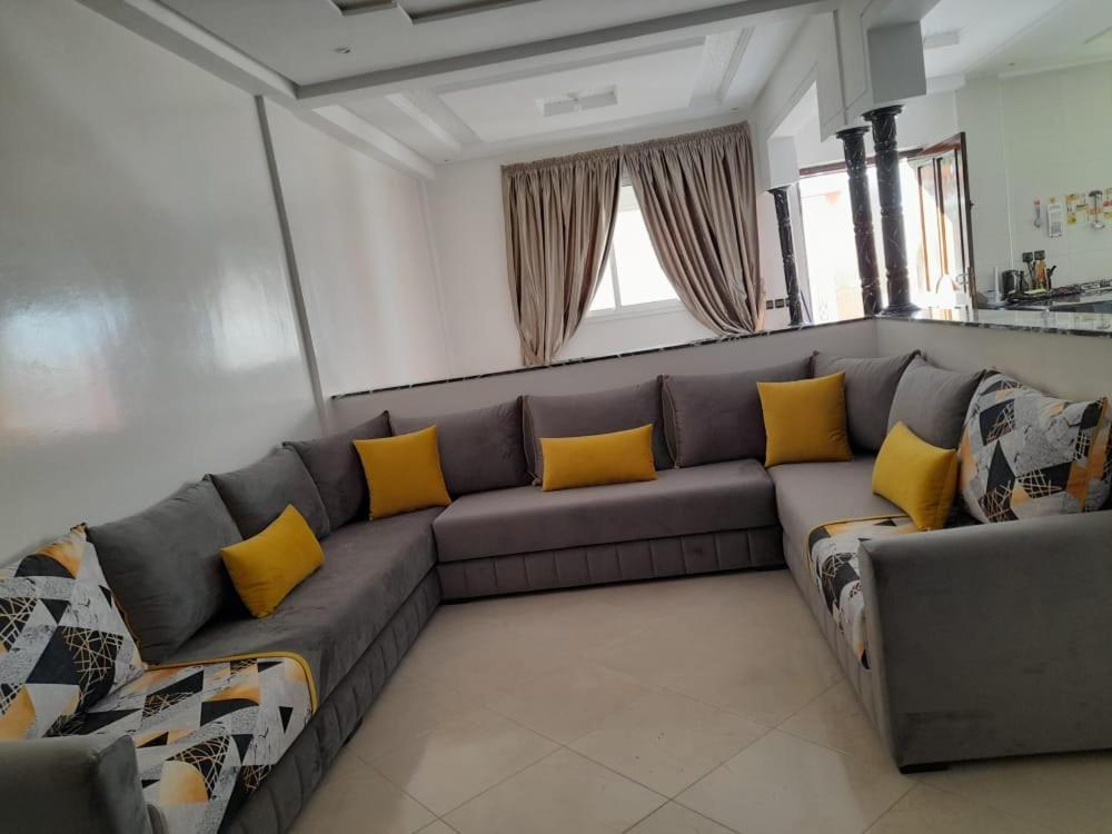 - un salon avec un canapé gris et des oreillers jaunes dans l'établissement Amam's Home, à Agadir