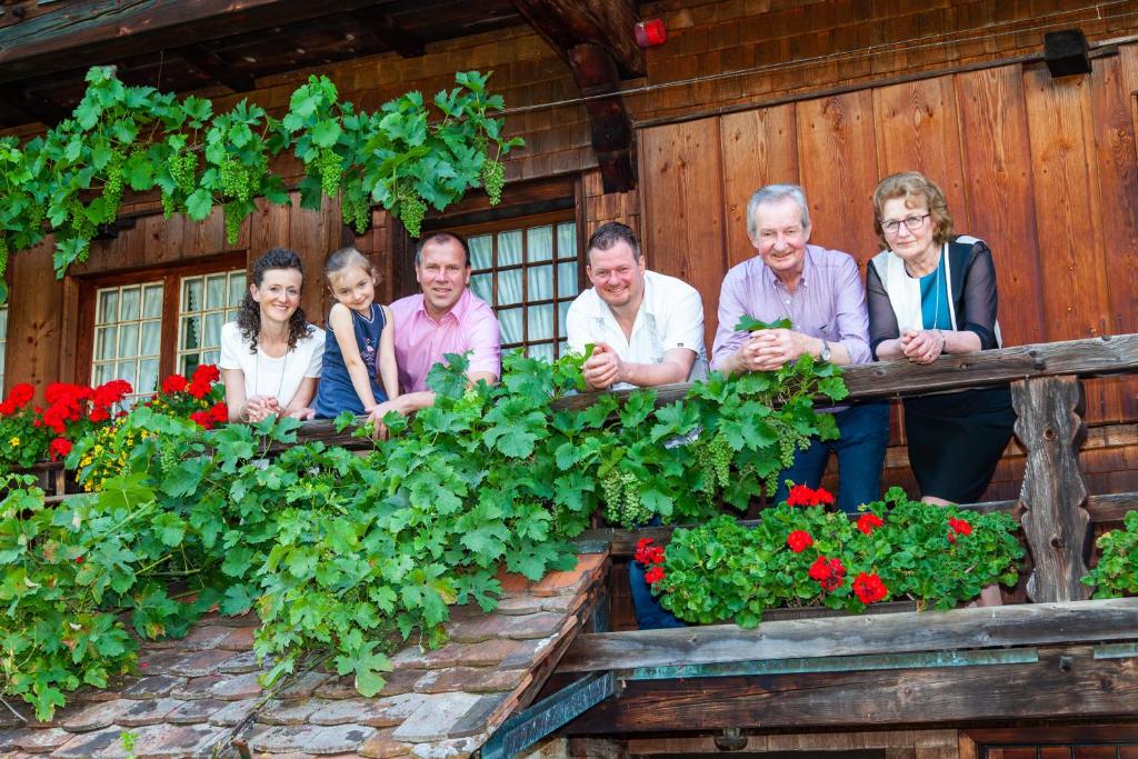 eine Gruppe von Personen, die auf einem Balkon mit Blumen stehen in der Unterkunft Gasthaus Rebstock in Simonswald