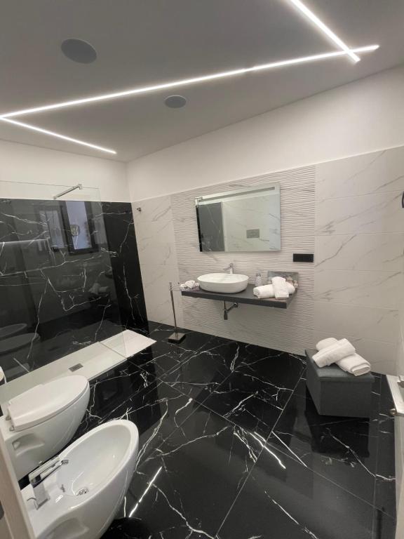 a black and white bathroom with a sink and a mirror at Case Porta San Salvatore Sciacca in Sciacca