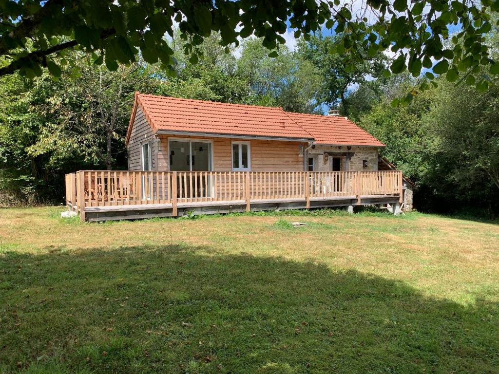 a small wooden cabin with a large deck at Petite maison Conjat in Saint-Julien-le-Petit