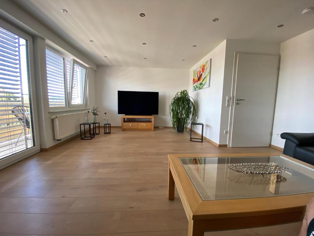 a living room with a flat screen tv and a table at Ferienwohnung am Holzberg in Volkach mit Weitblick in Volkach