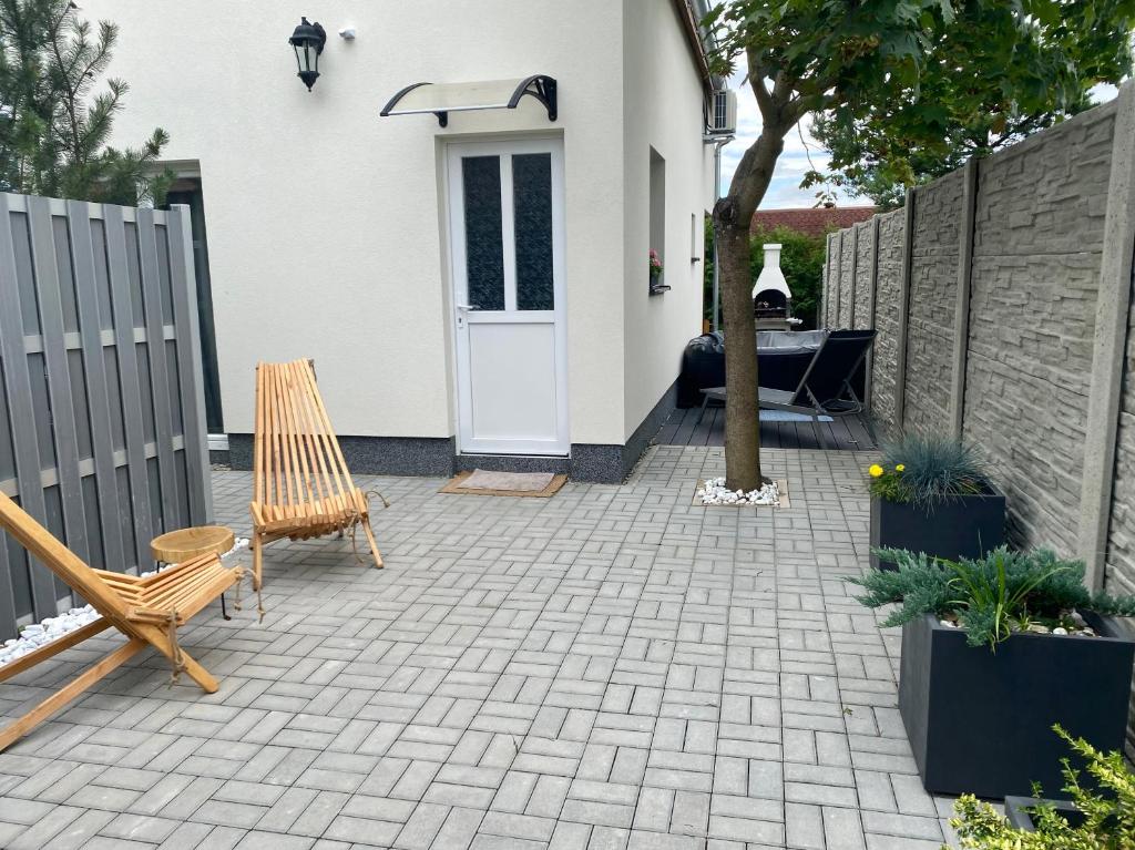 a patio with two chairs and a white door at Apartmán Provence Deluxe in Doksy