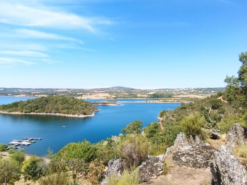 a view of a lake from a hill at Casas de Campo Podence in Macedo de Cavaleiros