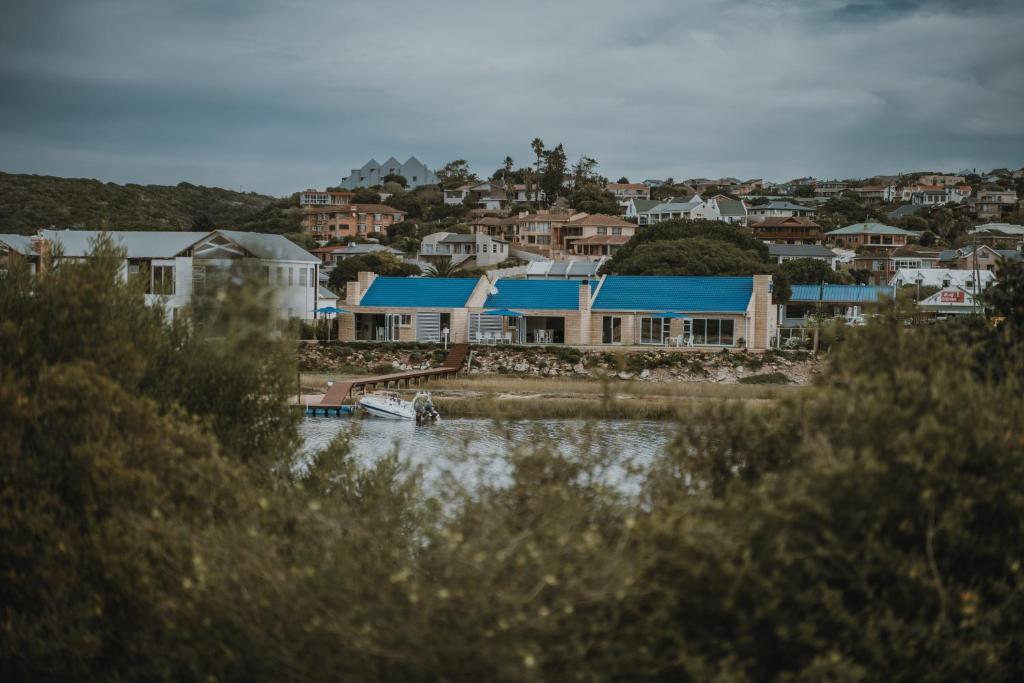 a city with houses and a boat in the water at Aloha Lodge in Stilbaai
