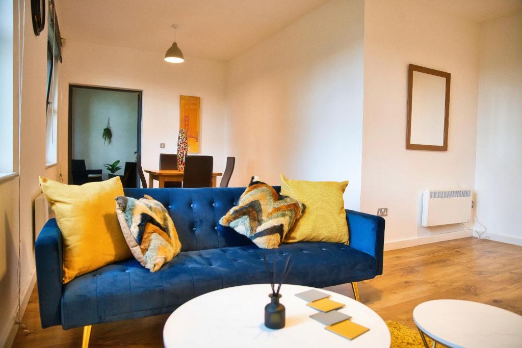 a living room with a blue couch and yellow pillows at Stunning Modern Coventry City Apartment Free WiFi in Coventry