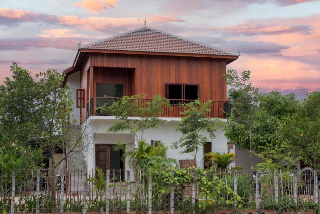 ein Haus mit einem Zaun davor in der Unterkunft Beyond Angkor Homestay - Private Floor 2-Bedroom & Living Room in Siem Reap