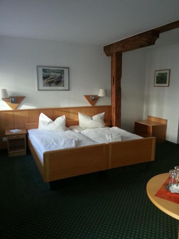 a bedroom with a large bed with white sheets at Hotel am Schloß in Schwerin