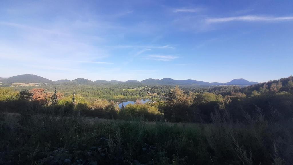 einen Blick auf ein Tal mit Bergen in der Ferne in der Unterkunft Gîte du sabotier Lamadon in Saint-Genès-Champanelle