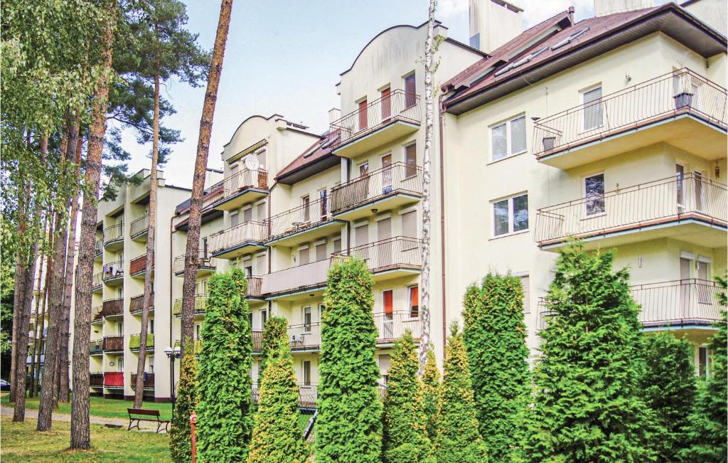 ミエンジズドロイェにあるStunning Apartment In Miedzyzdroje With 2 Bedrooms And Wifiの目の前に木々が生い茂るアパートメント